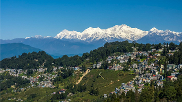 Stunning panoramic view of Darjeeling town with the snow-capped Kanchenjunga mountain range, a highlight of a Peer Baba tour package.