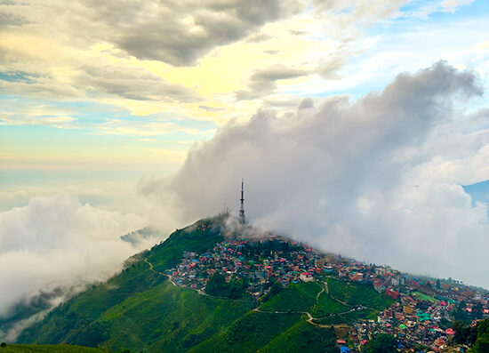 The scenic hill station of Kurseong enveloped in morning clouds, a highlight of a Peer Baba Darjeeling tour package.